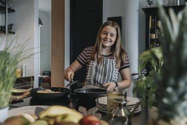 Teenagerin bereitet gesundes Mittagessen in der Küche vor - MFF05990