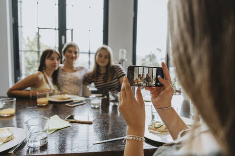 Group of teenage girls meeting for brunch, taking smartphone pictures stock photo