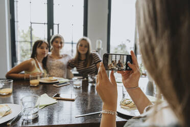 Gruppe von Teenagermädchen trifft sich zum Brunch und macht Smartphone-Fotos - MFF05997