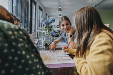 Mädchen im Teenageralter, die von zu Hause aus studieren und lernen und sich gegenseitig unterstützen - MFF06010