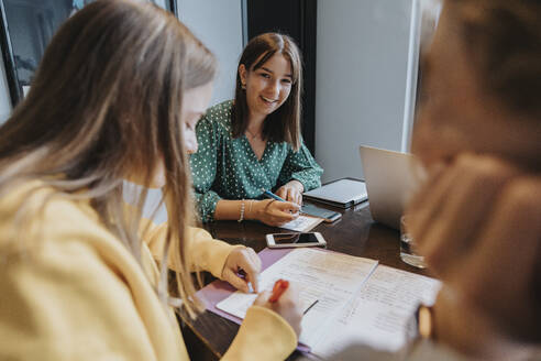 Mädchen im Teenageralter, die von zu Hause aus studieren und lernen und sich gegenseitig unterstützen - MFF06013