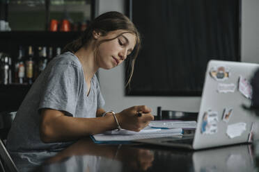 Teenage girl studying from home, using laptop - MFF06020