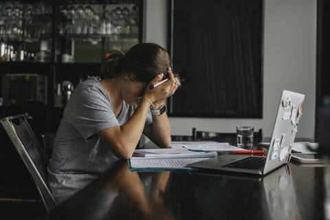 Teenage girl studying from home, using laptop stock photo