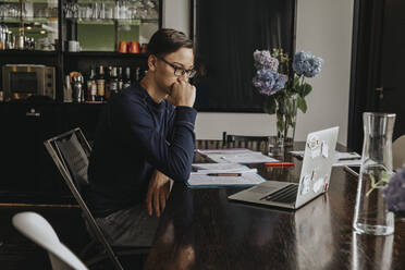 Young man studying from home, using laptop - MFF06027