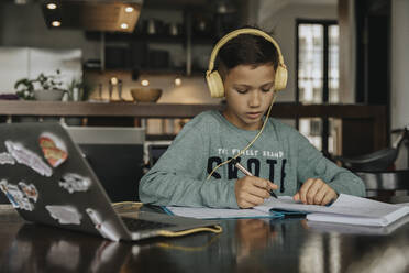Schoolboy learning at home, using laptop and headphones - MFF06033