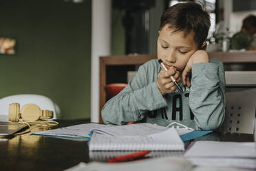 Schoolboy learning at home, head in hands, solving problem - MFF06040