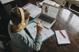 Schoolboy learning at home, using laptop and headphones - MFF06041