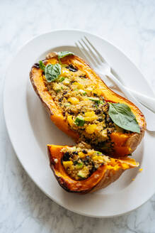 Stuffed squash with quinoa and vegetables on white plate - ADSF11819