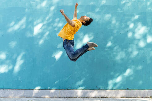 Lässiger Mann, der vor eine blaue Wand springt - AFVF07007