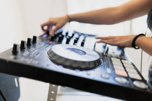 Hände eines weiblichen DJs beim Abmischen von Ton im Aufnahmestudio - MRRF00280