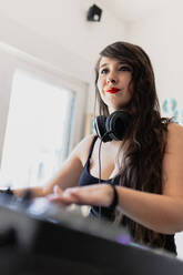 Female music producer using sound recording equipment at studio - MRRF00282