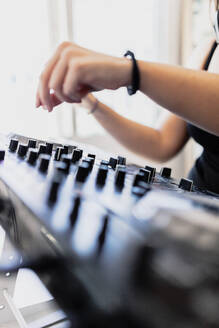 Hände eines weiblichen Club-DJs beim Abmischen von Ton im Aufnahmestudio - MRRF00284
