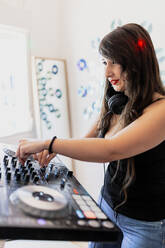 Beautiful club DJ using techno equipment at recording studio - MRRF00285