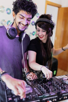 Glückliches DJ-Paar, das im Aufnahmestudio gemeinsam Ton mischt - MRRF00296