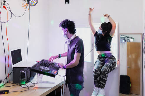 Männlicher Musiker mischt den Ton, während seine Freundin im Aufnahmestudio tanzt - MRRF00308