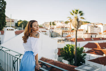 Schöne junge Frau lehnt am Geländer der Alfama, Lissabon, Portugal - DCRF00669