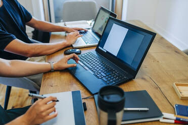 Webdesigner bei der Arbeit mit dem Laptop am Bürotisch - DCRF00683