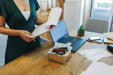 Midsection von weiblichen professionellen stehend mit Zwischenablage am Schreibtisch im Büro - DCRF00687