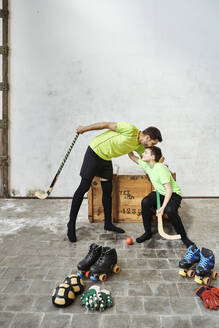 Man kissing son before roller hockey training at court - VEGF02815