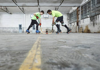 Oberflächennahe Ansicht von Vater und Sohn, die sich beim Rollhockeyspielen auf dem Platz gegenüberstehen - VEGF02828