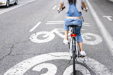 Tiefschnitt einer Frau beim Fahrradfahren auf einer Straße in der Stadt - JCMF01203