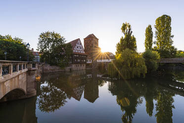 Deutschland, Bayern, Nürnberg, Weinstadel und Wasserturm spiegeln sich im Fluss Pegnitz bei Sonnenuntergang - WDF06224