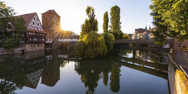 Deutschland, Bayern, Nürnberg, Henkersteg, Weinstadel und Wasserturm spiegeln sich im Fluss Pegnitz bei Sonnenuntergang - WDF06225