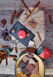 Von oben Schiefertafel mit Himbeermousse auf dem Tisch zwischen unordentlichen Zutaten mit Schokolade und Zimtstangen - ADSF12219