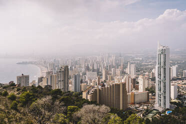 Stadtbild des dicht bebauten Stadtviertels Benidorm mit modernen Wolkenkratzern im Dunst in Spanien von oben - ADSF12233