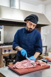 Chef cutting meat in kitchen - ADSF12306