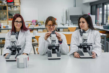 Female scientists using microscopes in lab - ADSF12416