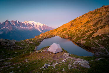 From above small tent and clear lake reflecting sky high in mountains in sunny day in Chamonix, Mont-Blanc - ADSF12503