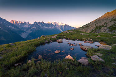 Von oben kleiner klarer See mit Stein auf dem Grund, der den Himmel hoch in den Bergen von Chamonix, Mont-Blanc, spiegelt - ADSF12504