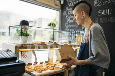 Waiter and customer at the counter in a cafe - GMLF00510