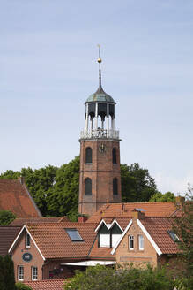 Deutschland, Niedersachsen, Ditzum, Glockenturm umgeben von Bürgerhäusern - WIF04305
