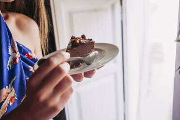 Frau isst ein Stück Kuchen zu Hause - LJF01747