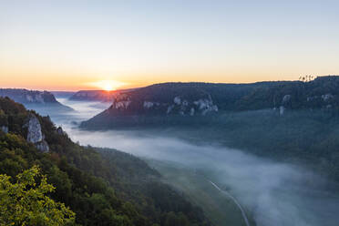 Deutschland, Baden-Württemberg, Blick auf das nebelumhüllte Donautal bei Sonnenaufgang - WDF06242