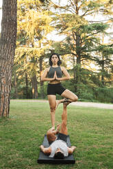 Boyfriend and girlfriend practicing acroyoga in park - MRRF00356