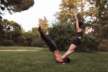 Male and female athletes practicing acroyoga in park - MRRF00369