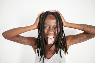 Cheerful woman smiling and whipping her dreadlocks while standing