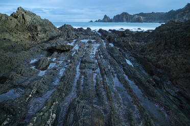 Beautiful seascape of Playa de Gueirua beach with rocks on misty day at Asturias, Spain - ADSF12532