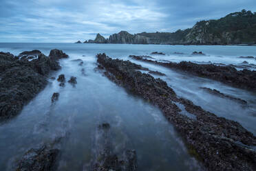 Beautiful seascape of Playa de Gueirua beach with rocks on misty day at Asturias, Spain - ADSF12533