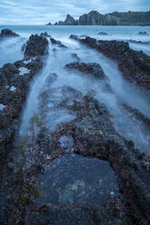 Beautiful seascape of Playa de Gueirua beach with rocks on misty day at Asturias, Spain - ADSF12534