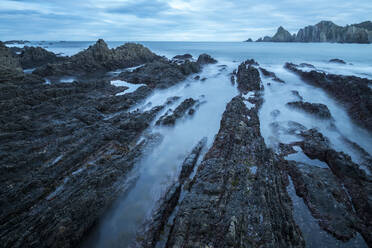 Beautiful seascape of Playa de Gueirua beach with rocks on misty day at Asturias, Spain - ADSF12535
