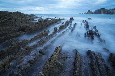 Beautiful seascape of Playa de Gueirua beach with rocks on misty day at Asturias, Spain - ADSF12536