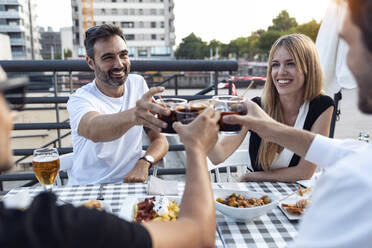 Happy friends toasting Spanish vermouth at sidewalk cafe - JSRF01106