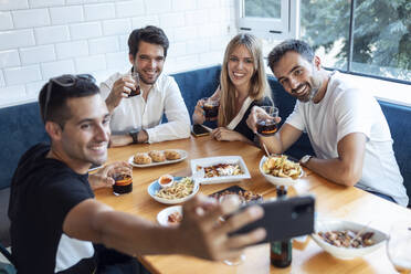 Gruppe von Freunden, die ein Selfie machen, während sie im Restaurant essen - JSRF01112