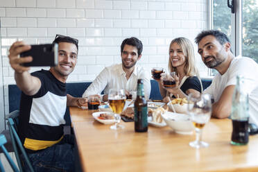 Freunde beim Mittagessen im Restaurant, während sie ein Selfie machen - JSRF01113