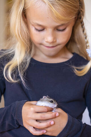 Niedliches kleines Mädchen spielt mit Hamster, lizenzfreies Stockfoto