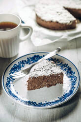 Ein Stück Schokoladenkühlschrankkuchen mit Kokosraspeln und eine Tasse Kaffee - IPF00544